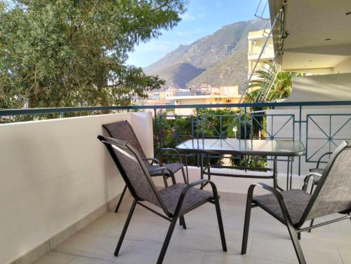 a patio with chairs and a table on a balcony at NikhsHome in Loutraki