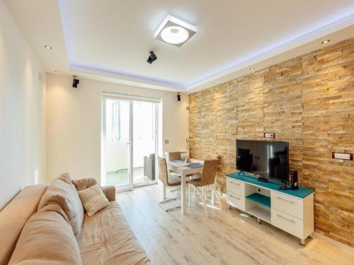 sala de estar con sofá y TV de pantalla plana en Apartment Petit Jolie, en Herceg-Novi