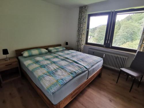 um quarto com uma cama, uma cadeira e uma janela em Ferienwohnungen Arnold Berchtesgaden em Berchtesgaden