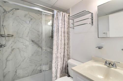 a white bathroom with a shower and a sink at DL104 Dunes Watch Oceanfront in Nags Head