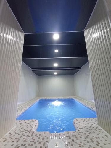 una gran piscina en una habitación con techo en DOM V CHIMGANE, en Kyzyldzhar