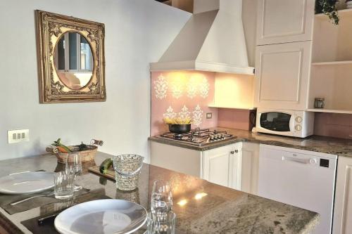 a kitchen with a counter with a sink and a microwave at Ca'Dinora - Caesar apartment in Bardolino