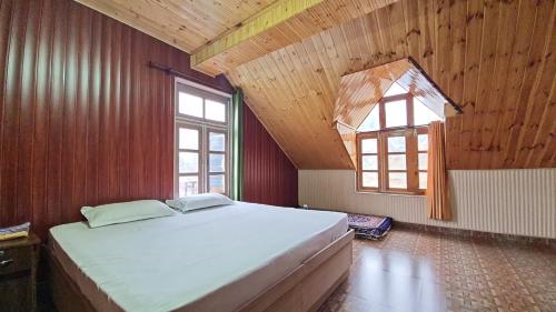 - une chambre avec un grand lit et 2 fenêtres dans l'établissement Beyond Rohtang, à Tāndi
