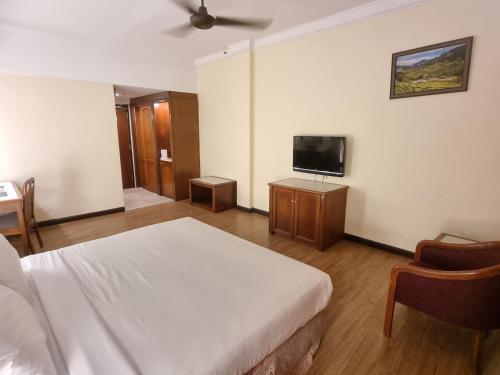 a bedroom with a bed and a flat screen tv at Heritage Hotel Cameron Highlands in Cameron Highlands