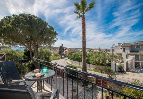 Un balcón con una mesa y una palmera en Araucaria Apartments, en Tsilivi