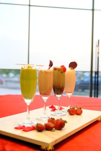 a group of three drinks in wine glasses on a tray at ACR Luxury Hotel in Mohali