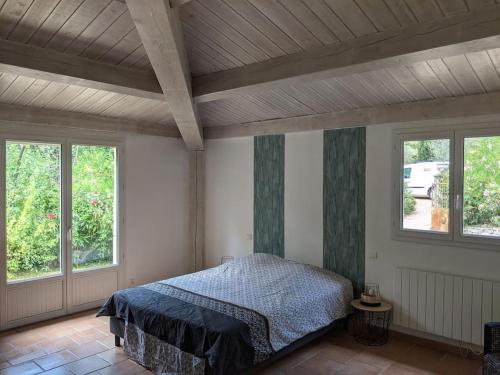 una camera con un letto in una stanza con finestre di MAS # PISCINE OLIVERAIE RUISSEAU CHEVAUX # SALAGOU a Lacoste