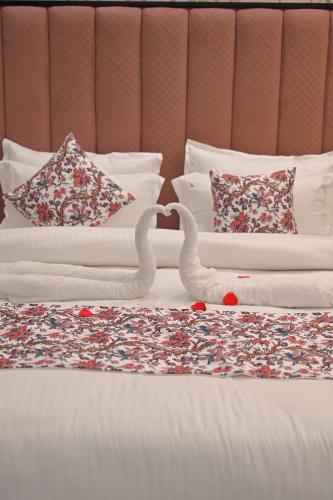 two swans making a heart on a bed at ACR Luxury Hotel in Mohali