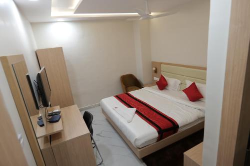 Habitación de hotel con cama con almohadas rojas en INDRALOK INN., en Hazārībāg