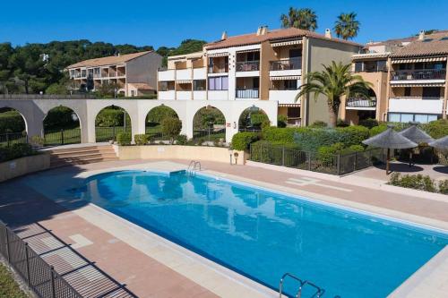 - une piscine en face d'un immeuble dans l'établissement T3 Escale à Giens, à Hyères