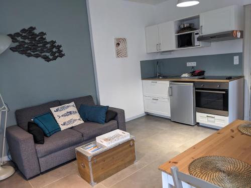 a living room with a couch and a kitchen at La corderie du Lude in Granville