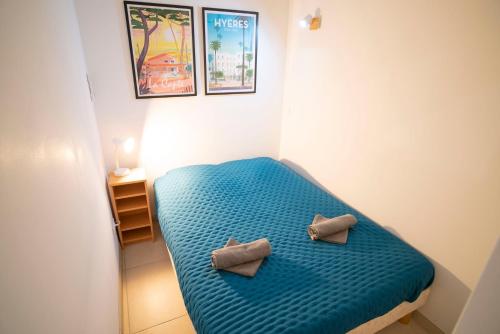 Cette petite chambre comprend un lit bleu avec deux oreillers. dans l'établissement T3 Escale à Giens, à Hyères