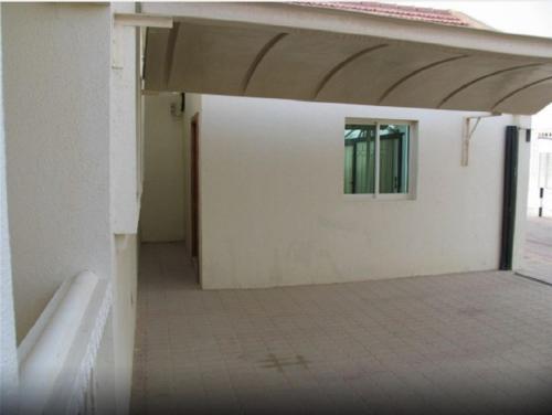 an empty room with a white wall and a window at Royal Residence Hotel Apartments in Umm Al Quwain