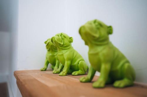 three green frogs sitting on a wooden table at Le Gué • Élégance fonctionnelle • Parking simple in Saint-Maur