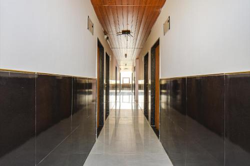 a hallway with wooden walls and a long hallway with a hallwayngth at FabHotel Prime Esta Inn - Nr Twin Tower, Viman Nagar in Pune
