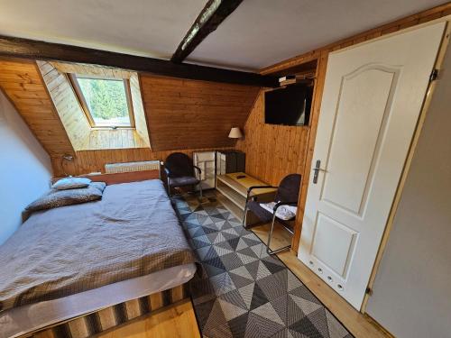 SpalonaにあるOsmelakowa Dolinaのベッドルーム1室(ベッド1台付)、窓、ドアが備わります。