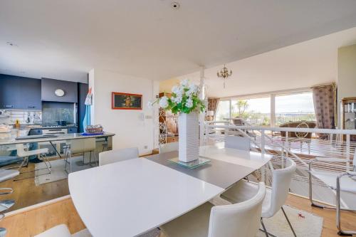 une cuisine et une salle à manger avec une table et des chaises blanches dans l'établissement Le Renversant - Appartement d'exception de 160m2, à Bordeaux