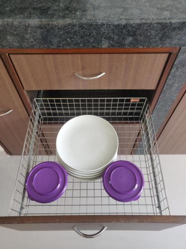 a plate and three purple plates in a drying rack at Sapana Meadows in Salcete
