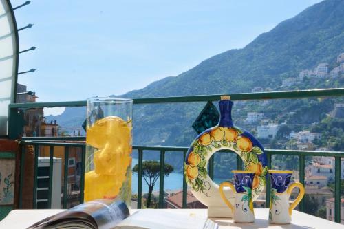 un tavolo con vaso e tazze sul balcone di Panoramic Flat Amalfi Coast - Sea View 2 a Vietri