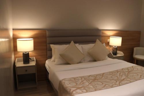 une chambre d'hôtel avec un lit et deux lampes dans l'établissement Caliraya Mountain Lake Resort, à Cavinti