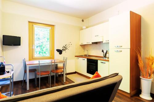 a kitchen with a table and a dining room at Residenza Alle Fonti palazzo del 1886 nel cuore di Vittorio Veneto in Vittorio Veneto