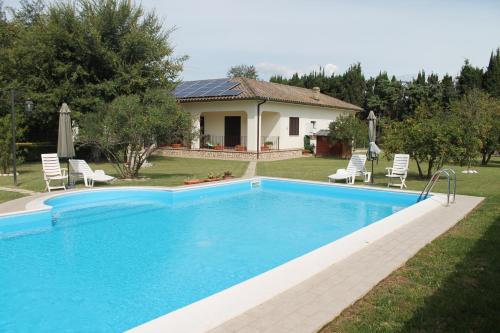 a swimming pool in front of a house at Relais La Mimosa in Pontinia