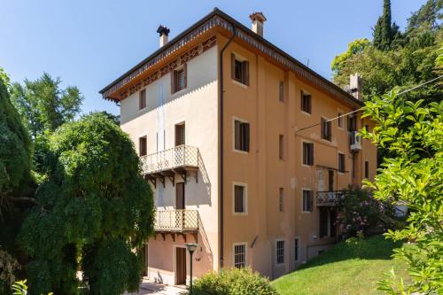 a building on a hill with trees at Residenza Alle Fonti palazzo del 1886 nel cuore di Vittorio Veneto in Vittorio Veneto