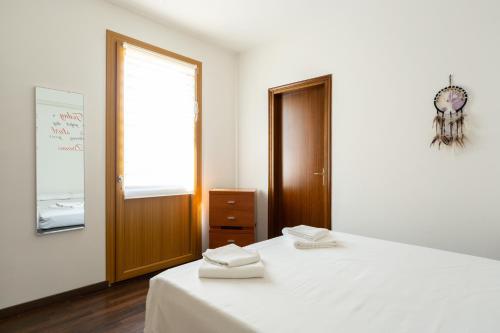 a bedroom with a bed with white sheets and a window at Residenza Alle Fonti palazzo del 1886 nel cuore di Vittorio Veneto in Vittorio Veneto