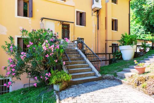 a set of stairs in front of a building with flowers at Residenza Alle Fonti palazzo del 1886 nel cuore di Vittorio Veneto in Vittorio Veneto