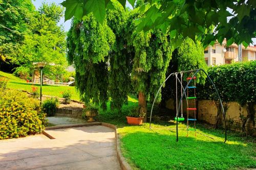 a playground in a yard with a tree and a swing at Residenza Alle Fonti palazzo del 1886 nel cuore di Vittorio Veneto in Vittorio Veneto