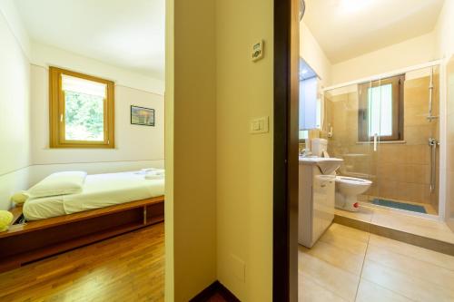 a bedroom with a bed and a bathroom at Residenza Alle Fonti palazzo del 1886 nel cuore di Vittorio Veneto in Vittorio Veneto
