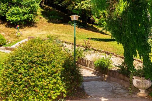 a street light next to some bushes and a sidewalk at Residenza Alle Fonti palazzo del 1886 nel cuore di Vittorio Veneto in Vittorio Veneto