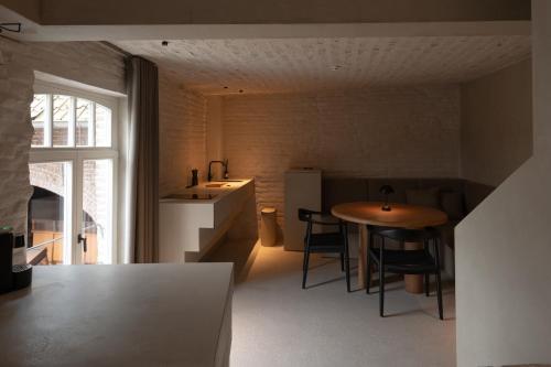 een keuken met een tafel en een keuken met een wastafel bij Luxe in Het Posthuis - nieuwe Stijlvolle Verblijven in Oud-Rekem in Lanaken