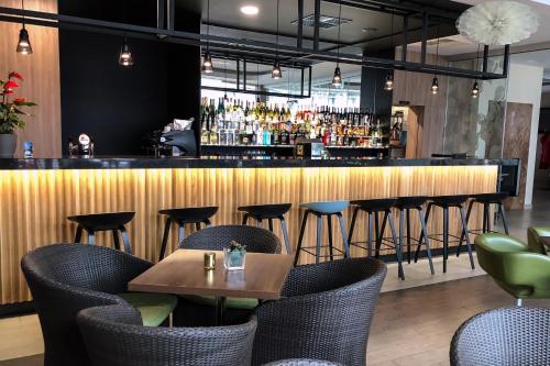 a restaurant with a bar with chairs and a table at Hotel Ponteo - Activity Park in Bratislava