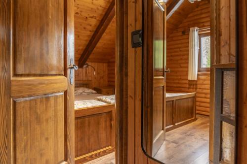 an open door of a wooden cabin with a bedroom at Cozy Bear Cabin in Brestova Draga
