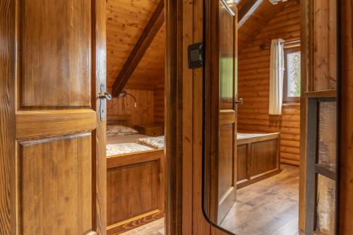an open door of a wooden cabin with a bedroom at Kuća za odmor Cozy Bear Cabin in Brestova Draga
