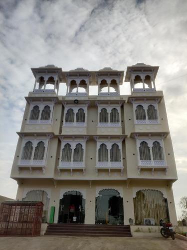 um edifício branco com janelas e um céu em THE HAMIRGARH PALACE em Rājsamand