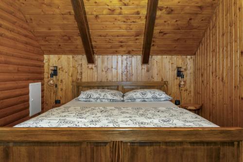 a bedroom with a bed in a wooden cabin at Cozy Bear Cabin in Brestova Draga