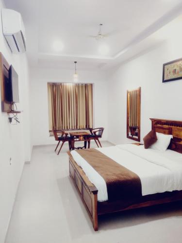 um quarto com uma cama grande e uma mesa em THE HAMIRGARH PALACE em Rājsamand