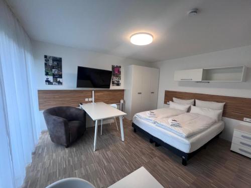 a bedroom with a bed and a table and a chair at NewAge Boardinghaus P5 in Heilbronn
