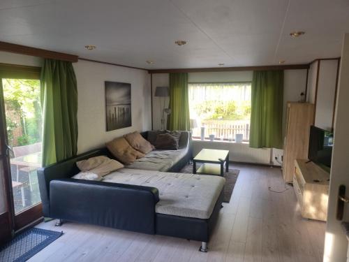 uma sala de estar com um sofá e uma televisão em Ferienwohnung direkt am Strand in Makkum em Makkum