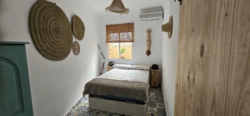 Habitación pequeña con cama y ventana en casa gecko, en Benalmádena