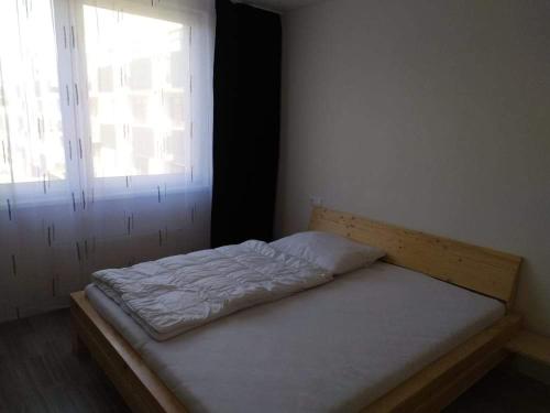 a small bed in a room with a window at Apartment 33 Mlynská Bašta in Košice