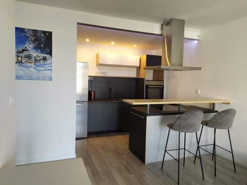 a kitchen with two bar stools and a counter at Apartment 33 Mlynská Bašta in Košice