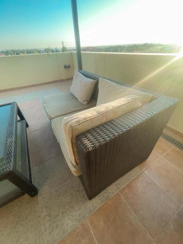 a wicker couch sitting on top of a balcony at Casa Maria-Anneta in Kalyves Poligirou