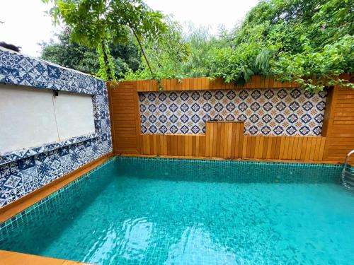 a swimming pool in front of a wooden fence at Villa Amarela in Panaji