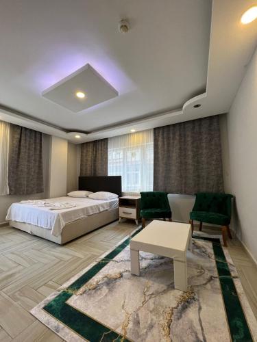 a bedroom with a bed and a couch and a table at Luu Hotel in Çorlu