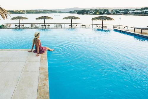 a woman sitting on the edge of a swimming pool at Iririki Island Resort & Spa in Port Vila