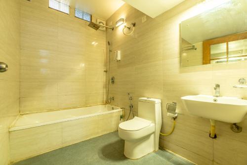 łazienka z toaletą, umywalką i wanną w obiekcie Seasons Suites - JP Nagar w mieście Bengaluru