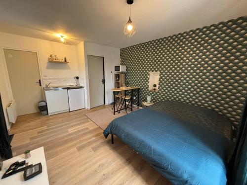 une chambre avec un lit bleu et une cuisine dans l'établissement Appartement Moderne, à La Roche-sur-Yon